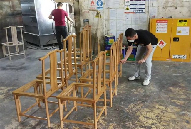 湖南人家湘菜馆水曲柳实木官帽椅由海德利家具厂设计生产，正在油漆房做油漆质量检测